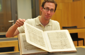 Musikwissenschaftler Dominik Hink mit einer historischen Ausgabe von Hndels „Judas Maccabaeus" aus der Santini-Sammlung der Dizesan-Bibliothek in Mnster.
