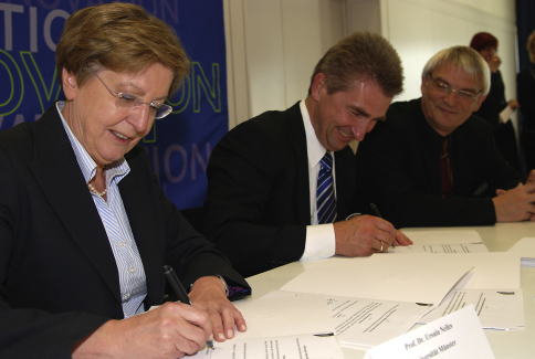Rektorin Prof. Dr. Ursula Nelles und Minister Prof. Dr. Andreas Pinkwart besiegeln mit ihrer Unterschrift die HMOP-Vereinbarung.