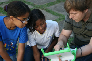 Projektleiter Thomas Bartoschek erklärt  Grundschulkindern die Aufgaben am 100-Dollar-Laptop.