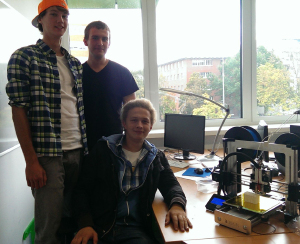 Die Schler Erik und Julius drucken gemeinsam mit Geoinformatikstudent Christopher (v. l.) an einem 3-D-Drucker ein Havixbecker Haus im Modell.