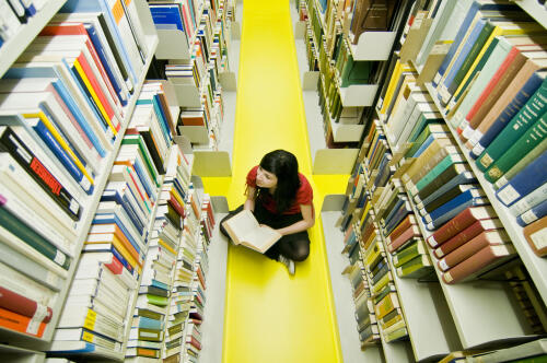 Studentin zwischen Bücherregalen