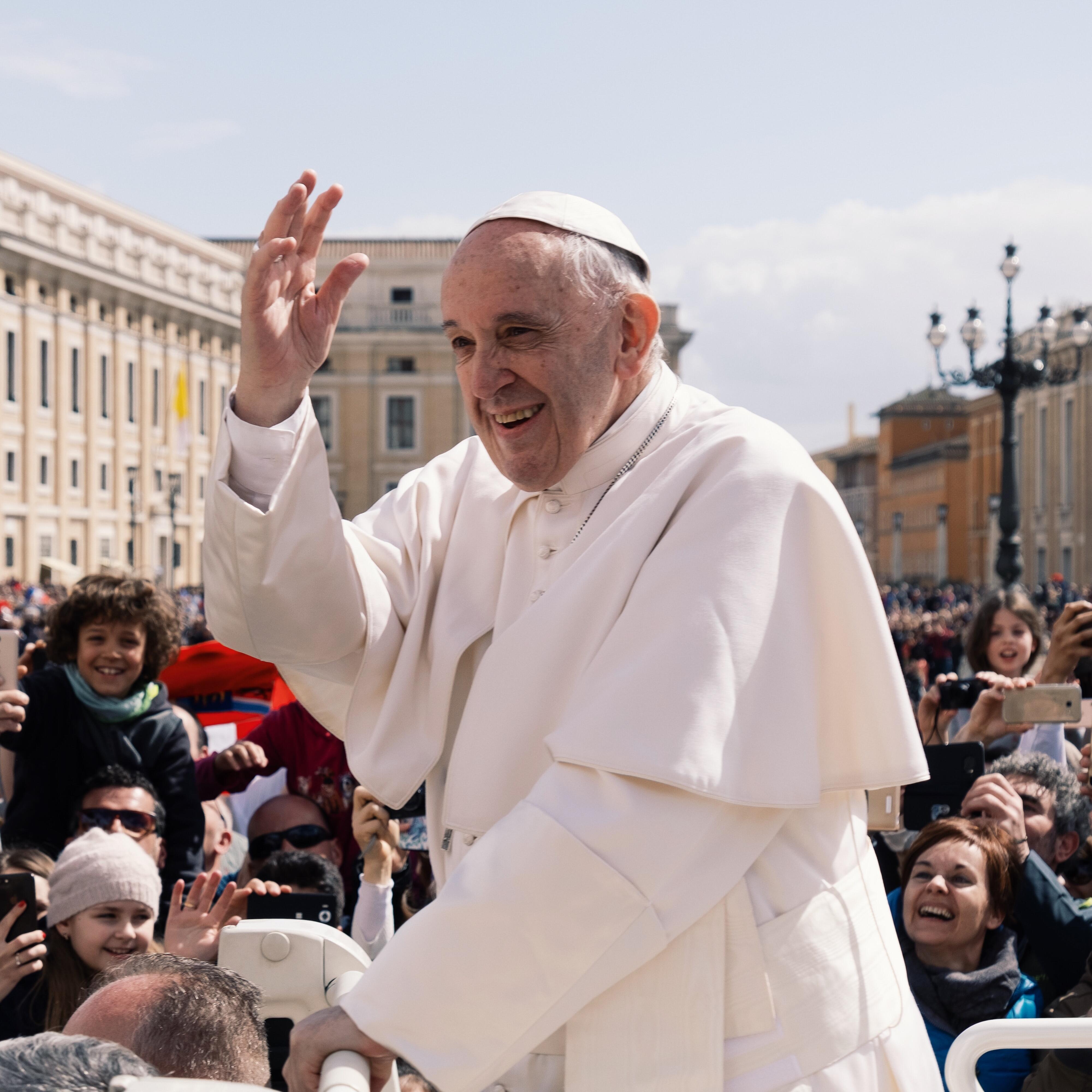 Papst Franziskus winkt Menschen auf dem Petersplatz zu