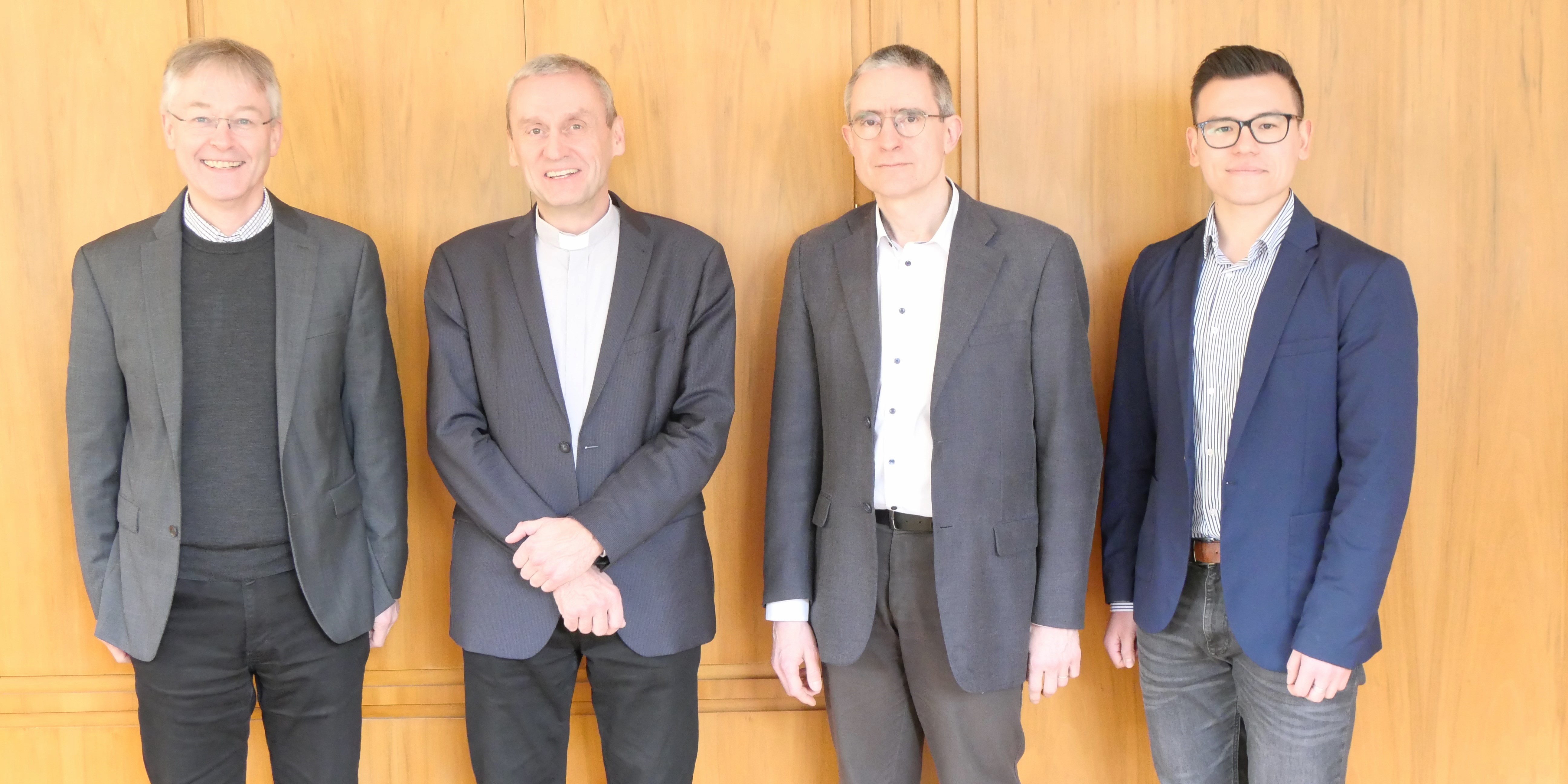 Prof. Dr. Norbert Köster, Prof. Dr. Marcin Worbs, Prof. Dr. Clemens Leonhard und Marco Xu stehend nebeneinander und lächeln in die Kamera