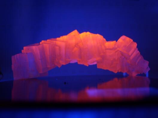 Wenn man Steinsalz mit UV-Licht bestrahlt, kann es intensiv orange leuchten.