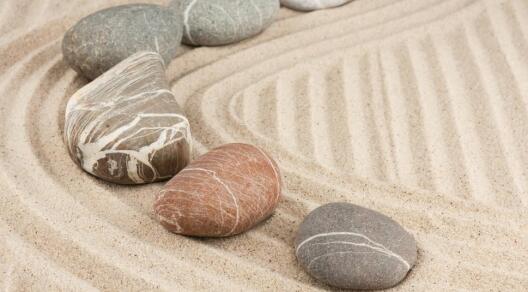 mehrere Steine auf geharktem Sand