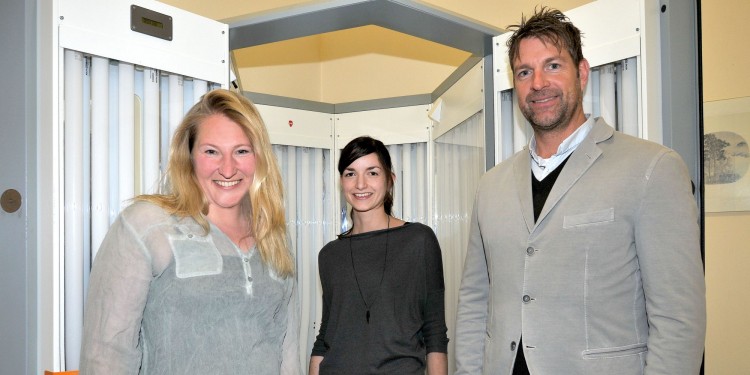 Prof. Karin Loser, Johanna Breuer and Prof. Heinz Wiendl (from left) in front of the UV chamber, in which the patients taking part in the study were subjected to radiation for six weeks<address>© FZ/Deiters</address>