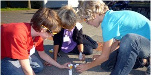 Kinder bauen eine Rakete bei einem MExLab-Workshop (oben). Unten: Das Dreieck der Nachhaltigkeit<address>© MExLab Physik/ifgi</address>