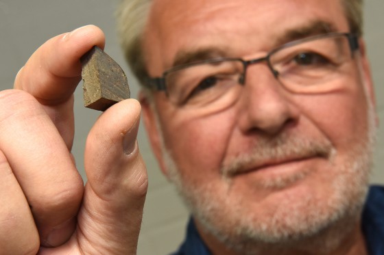 Namenspatron Addi Bischoff mit einem Stückchen des Meteoriten, in dem ein Einschluss des &quot;Addibischoffits&quot; gefunden wurde.<address>© WWU / Peter Grewer</address>