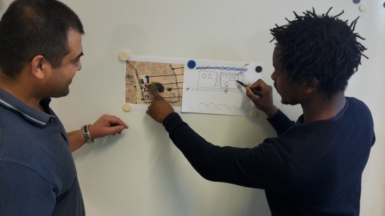 Malumbo Chipofya zeigt ein Gebäude auf einer Luftaufnahme und auf einer handgezeichneten Skizze im Vergleich.