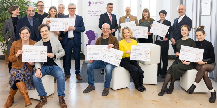 Der Vorstandsvorsitzende der Universitätsgesellschaft, Dr. Paul-Josef Patt (hintere Reihe, 1.v.r.), und WWU-Rektor Prof. Dr. Johannes Wessels (hintere Reihe, 5.v.r.) übergaben den Projektverantwortlichen symbolische Schecks.<address>© WWU - Peter Leßmann</address>