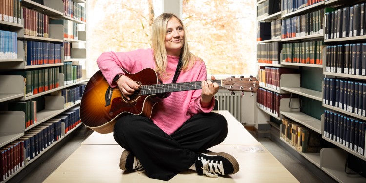 Wenn Kommunikationswissenschaftlerin Jo Marie Dominiak Gitarre spielt und singt, taucht sie in eine andere Welt ein. Das Musizieren ist für sie eine willkommene Ergänzung zum Arbeitsalltag.<address>© Uni MS - Peter Leßmann</address>