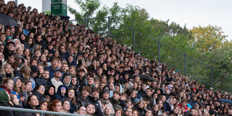 Zu sehen ist ein Teil der Haupttribüne mit Studierenden, jeder Platz ist besetzt.<address>© Uni MS - Brigitte Heeke</address>
