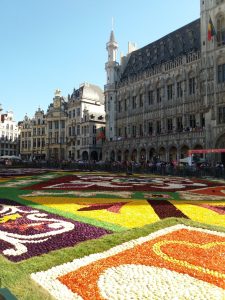 Wie ein Teppich liegen viele Blumen in gelb, grün, orange und violett auf dem Grand-Place in Brüssel.