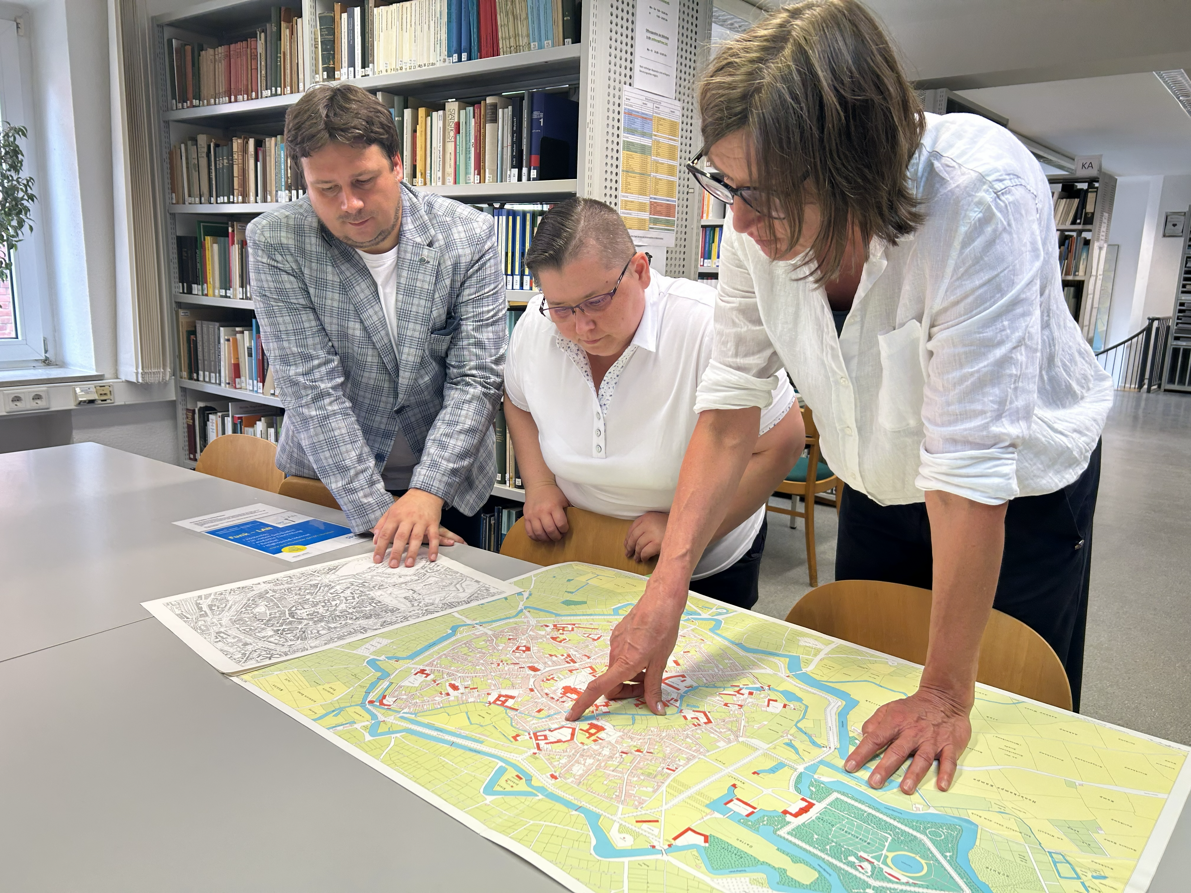 Angelika Lampen mit Agnieszka Pilarska und Radosław Golba in der Bibliothek