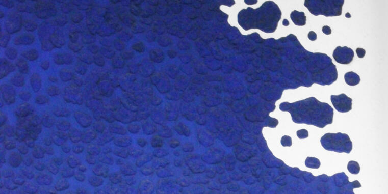 Close-up of a textured surface in dark blue with white spots. The surface appears irregular and features a type of pattern or texture. 