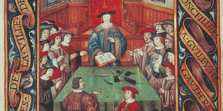 Eine spätmittelalterliche Buchmalerei, die eine Versammlung von Männern an einem Tisch zeigt. In der Mitte thront ein Mann in einem blauen Gewand, der ein aufgeschlagenes Buch hält. Er ist von Ratsherren oder Gelehrten in historischen Gewändern und Kappen umgeben. Der Tisch ist mit einem grünen Tuch bedeckt, auf dem Schreibutensilien liegen. Die Szene ist von dekorativen Schriftbändern mit französischem Text gerahmt.