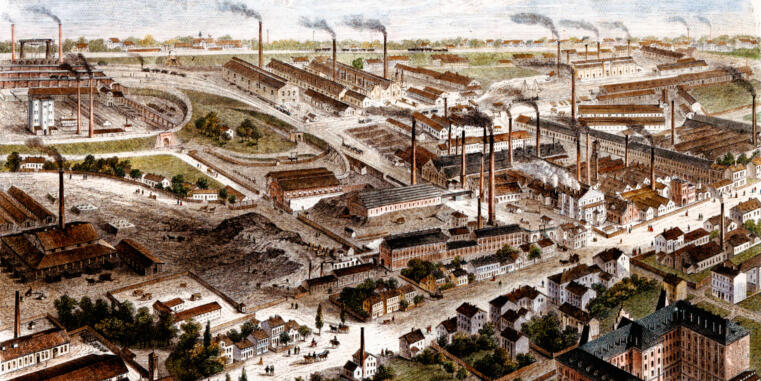 Historic panoramic view of a large industrial area with factory buildings, numerous smoking chimneys, railway tracks, and adjacent residential development.