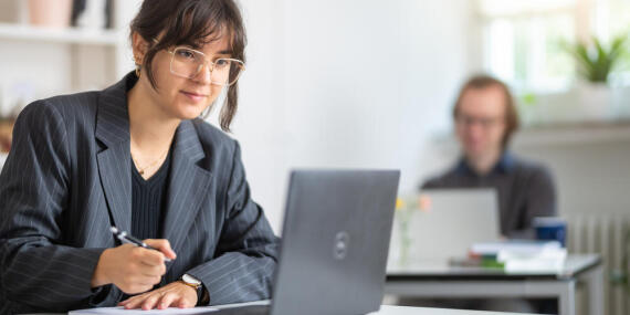 Teilnehmer und Teilnehmerin an Laptops im Seminarraum OG