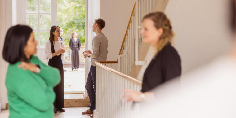 Teilnehmerinnen und Teilnehmer unterhalten sich vor der Tür der Schlossterrasse