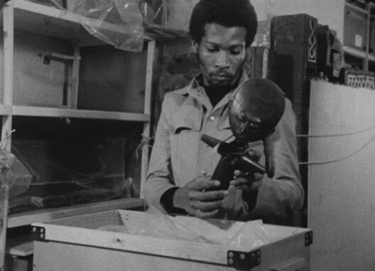 Mann nimmt eine Maske aus einer Kiste – Filmstill aus Nii Kwate Owoo, YOU HIDE ME, 1970
