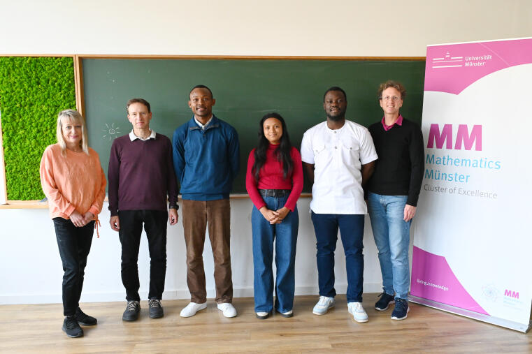 The YAM Fellows 2025/2026: David Jean Baptiste Bilong, Gilles Jordan Pedieu Tcheuha, and Miarisoa Elalie Rasamimanana, with Anke Pietsch (programme management assistant) and Raimar Wulkenhaar (academic coordinator) on the left, and spokesperson Mario Ohlberger on the right.