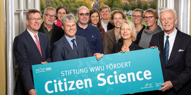 Mitglieder der Citizen-Science-AG mit Plakat "Stiftung WWU fördert Citizen Science"