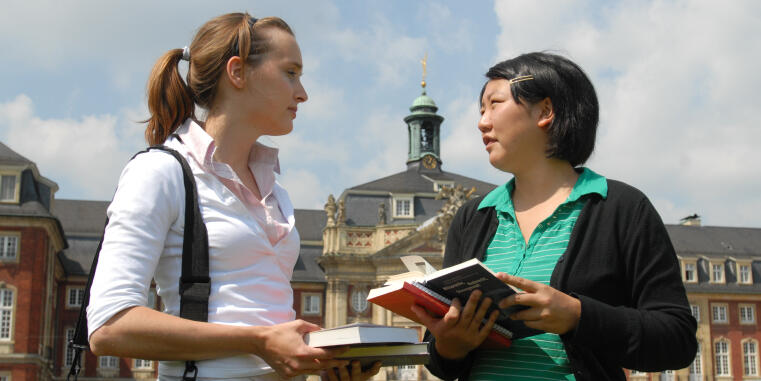 Two students in front of the castle in Münster