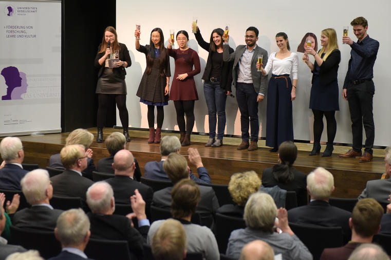 Foto von acht Personen auf einer Bühne vor Publikum