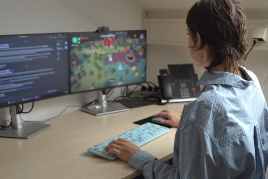 Eine Person sitzt am PC und spielt ein Videospiel