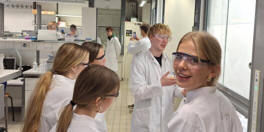 Schüler*innen kriegen von einem Studierenden vorm Abzug eine Erklärung.