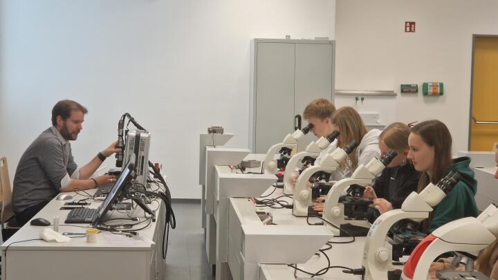Detailansicht: Dr. Fabian Herrmann erläutert die Besonderheiten der mit dem Mikroskop untersuchten Pflanzenprobe.