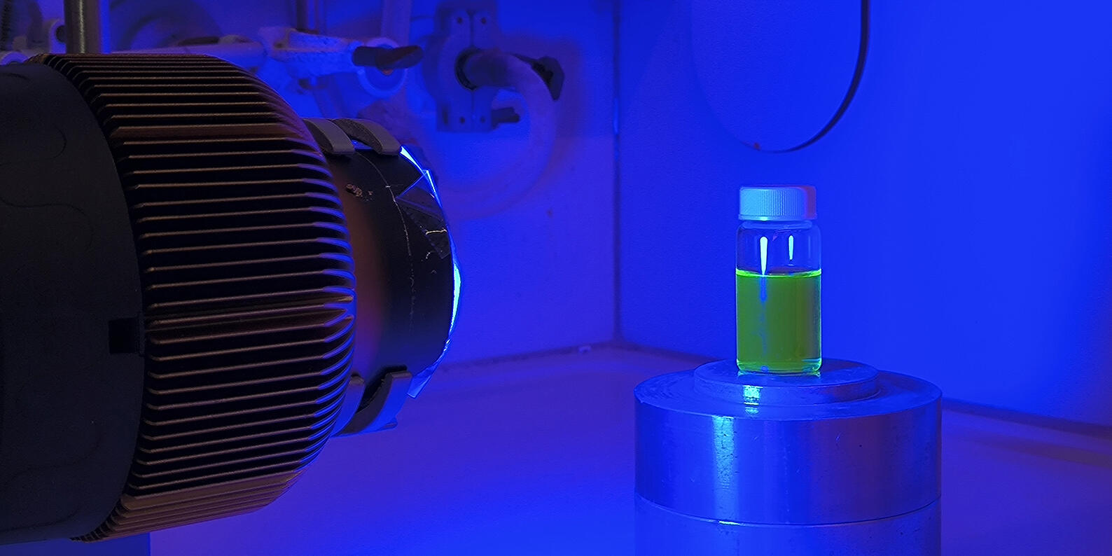 Ein Vial befüllt mit Flüssigkeit wird mit blauem Licht bestrahlt