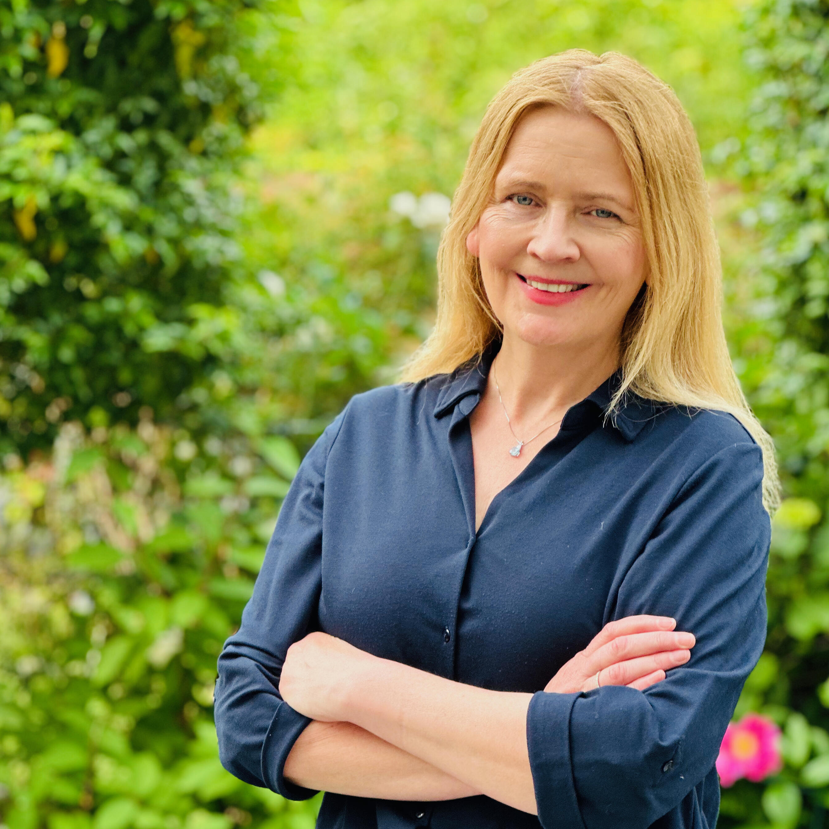 Ein Portrait von Professorin Doktorin Annette Marohn mit Büschen im Hintergrund.