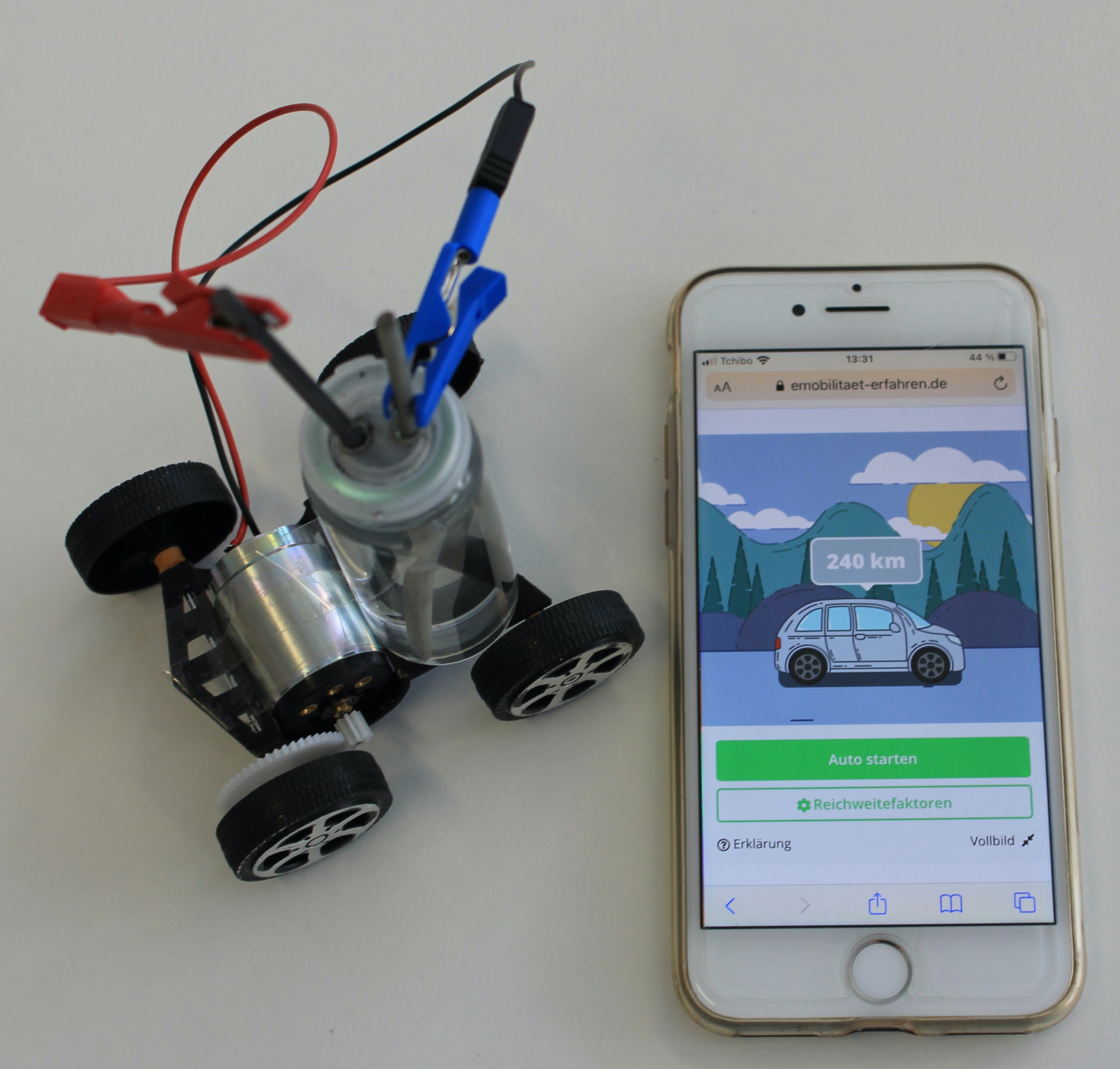 Modell eines Elektoautos mit Smartphone als Messgerät