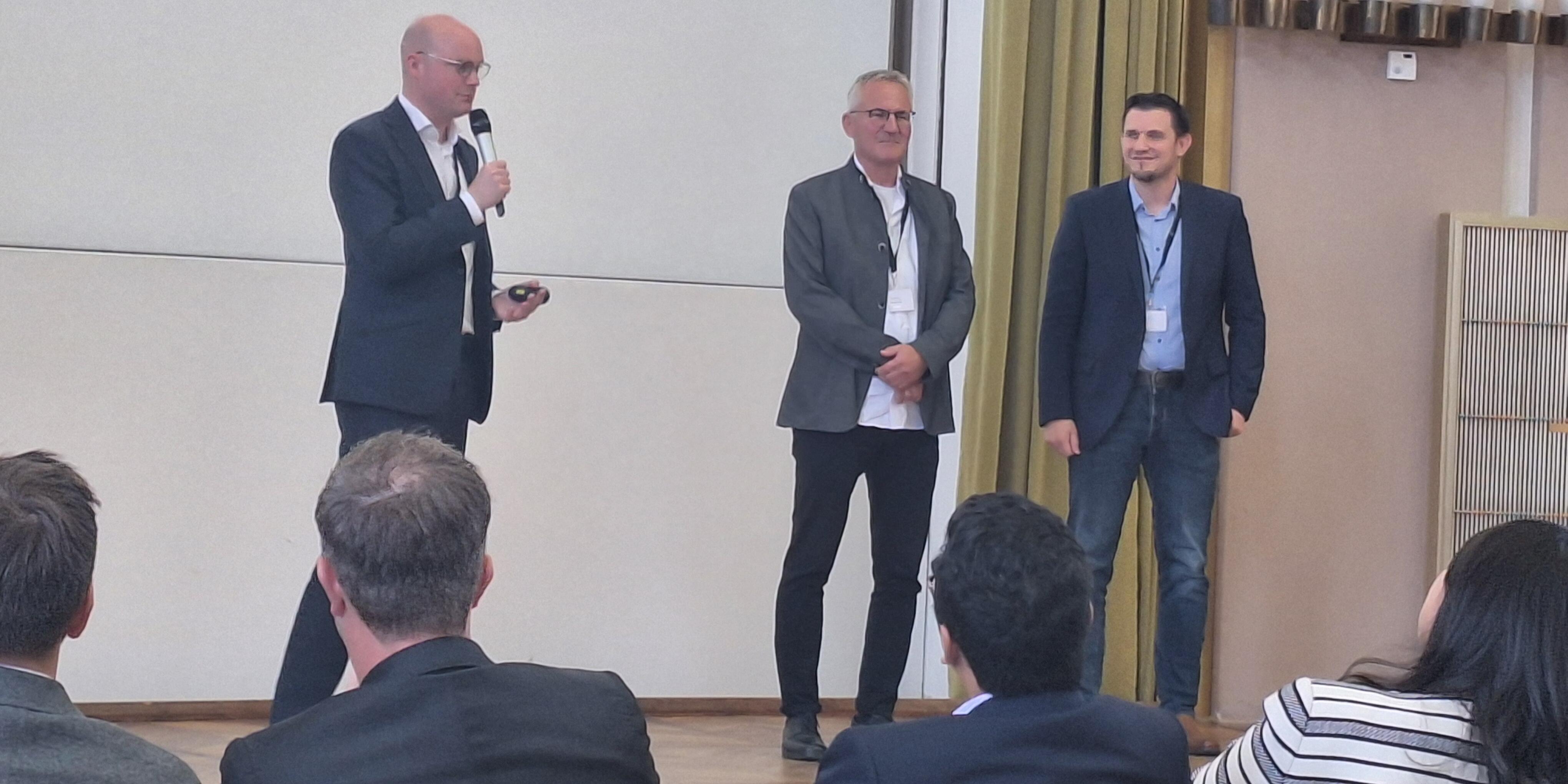 Die Professoren Stephan von Delft, Jens Leker und Simon Lux stehen für das Schlußwort nebeneinander auf der Bühne.