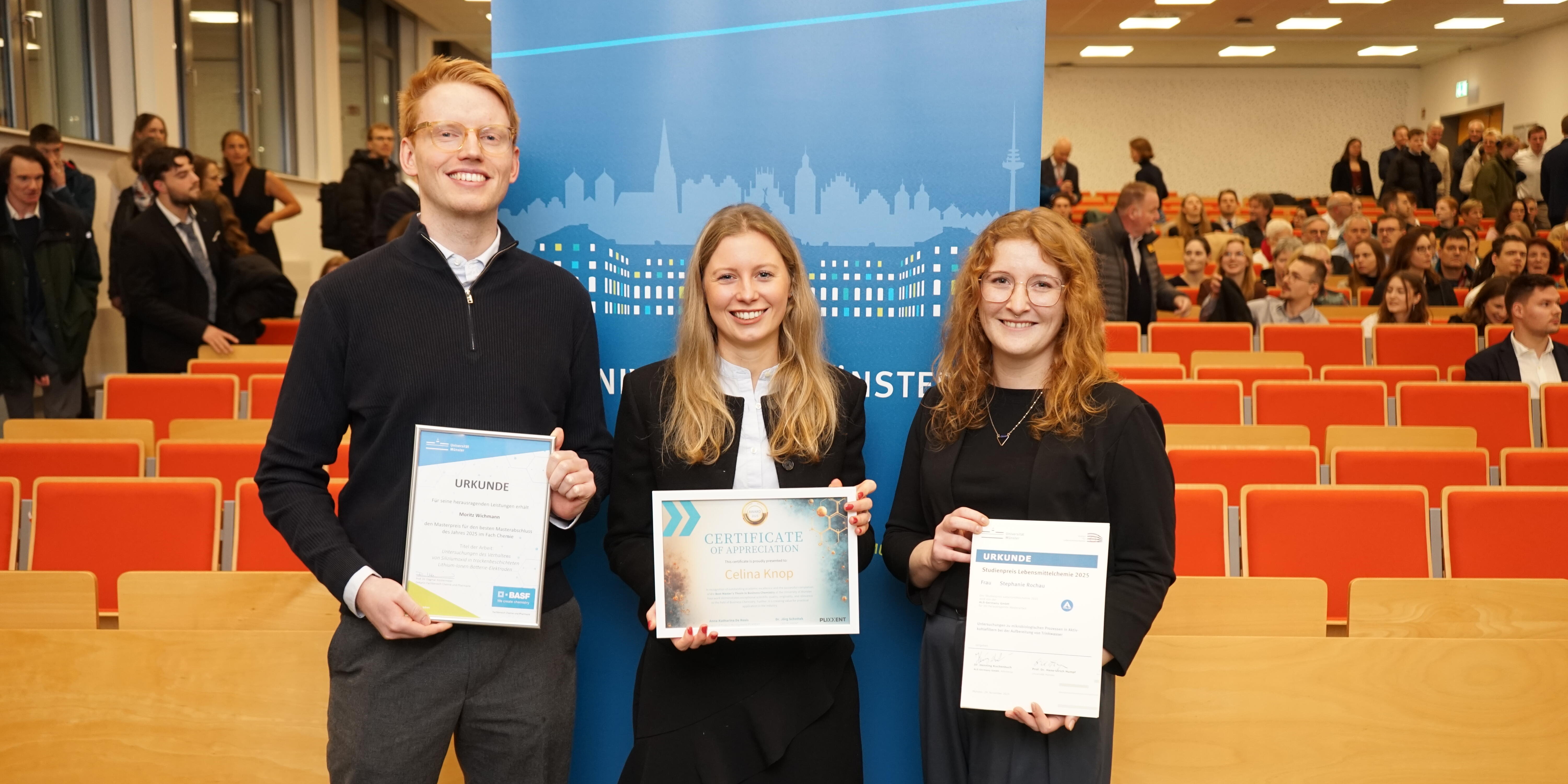 Die Preisträger*innen (V. l. n. r.) Moritz Wichmann (Chemie), Celina Knop (Wirtschaftschemie) und Stephanie Rochau (Lebensmittelchemie) zeigen nebeneinander ihre Urkunden.