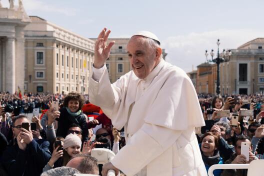 Papst Franziskus winkt Menschen auf dem Petersplatz zu