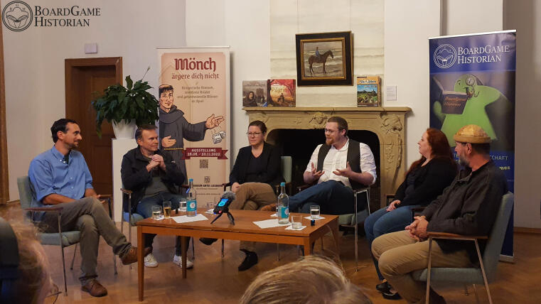 Teilnehmer:innen der Podiumsdiskussion disktuieren vor Kamin im Museum Abtei Liesborn