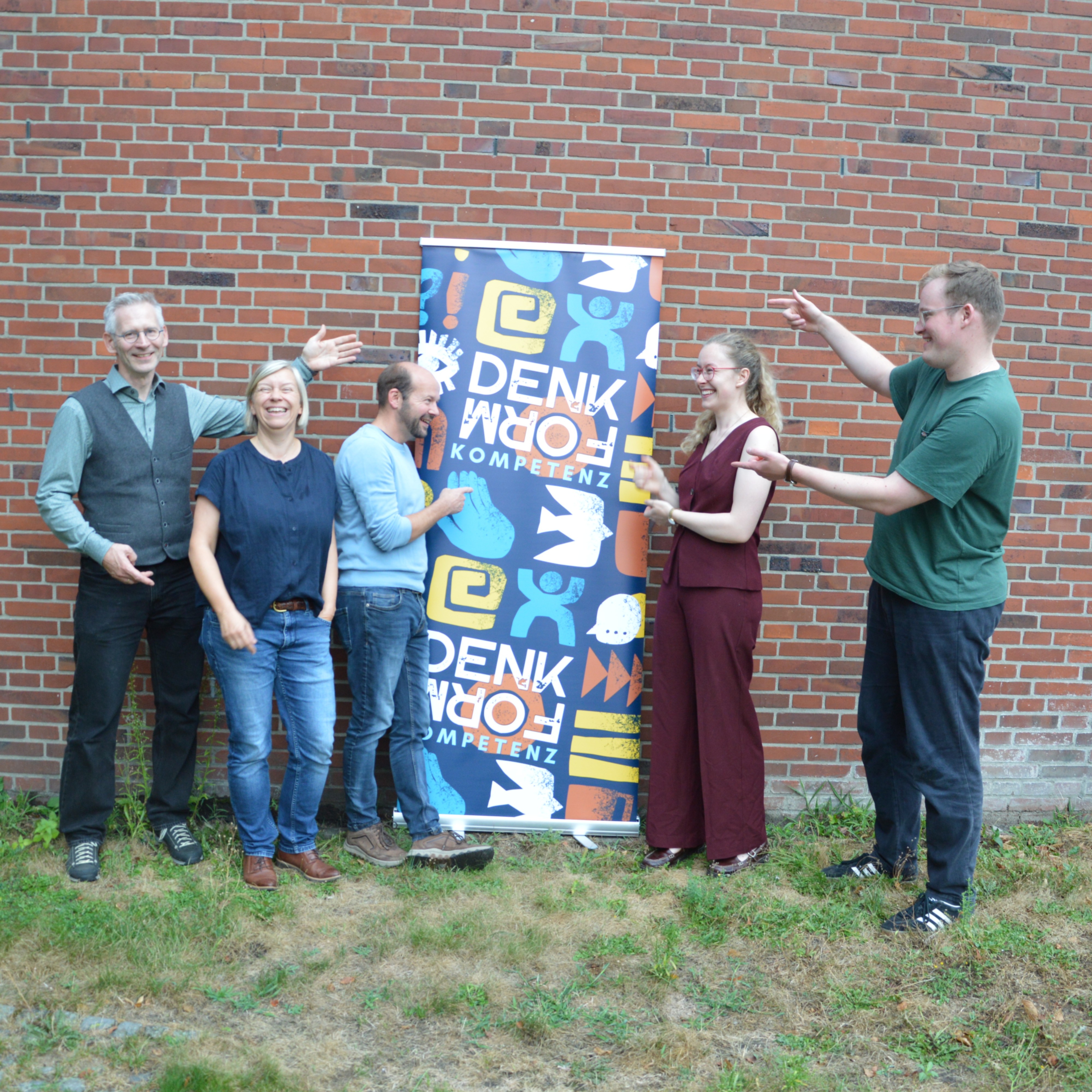 Das Vorbereitungsteam vor dem Plakat zur Werkstatt