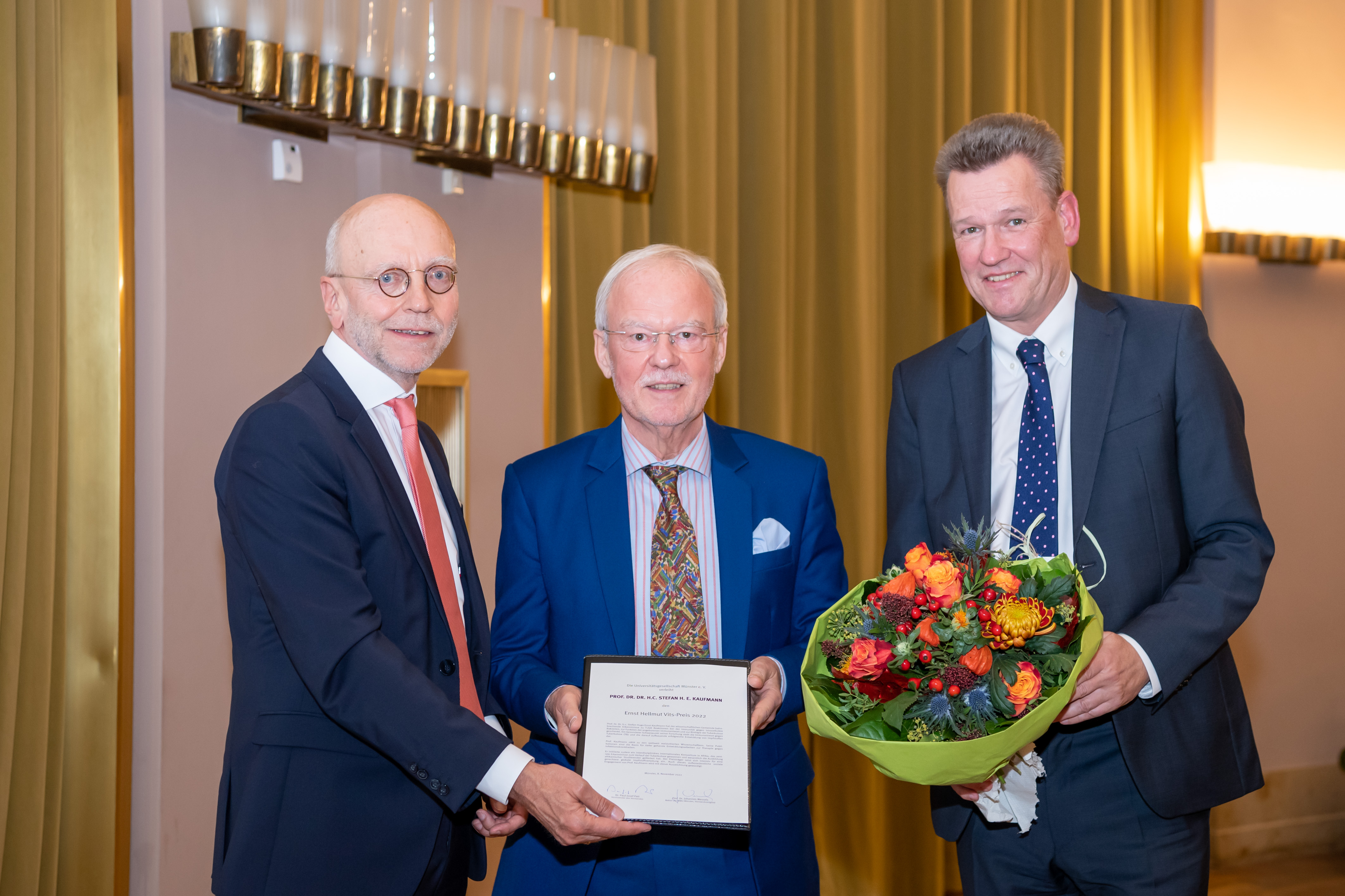 Der Vorstandsvorsitzende der Universitätsgesellschaft, Dr. Paul-Josef Patt (l.), und WWU-Rektor Prof. Dr. Johannes Wessels (r.) gratulierten dem Preisträger Prof. Dr. Stefan Hugo Ernst Kaufmann