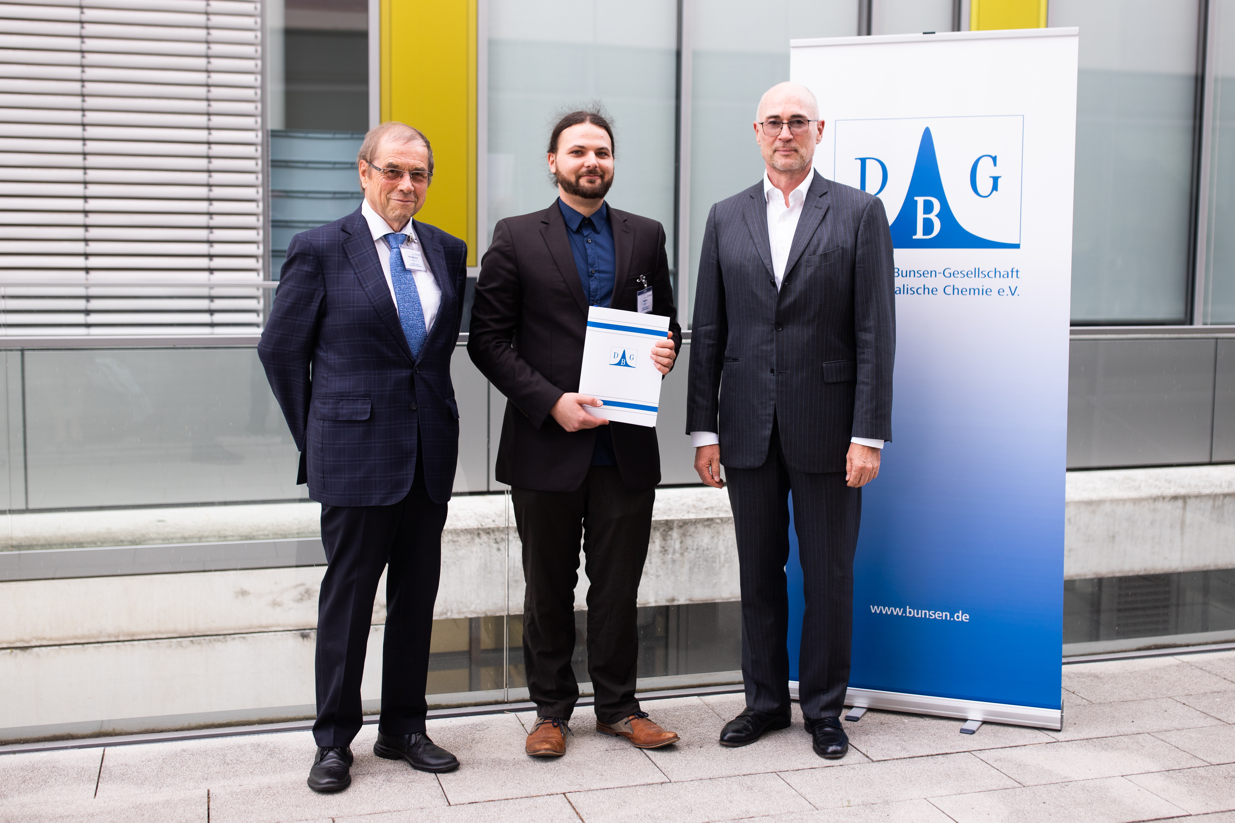 Prof. Dr. Dr. h.c. Rolf Hempelmann, Laudator (li.) und Dr. Florian Budde, Erster Vorsitzender der DBG 8re.) gratulieren dem Preisträger Dr. Daniel Rauber (mi.)