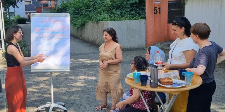 Workshoptreffen von 6 Teilnehmerinnen vor Wohnblock in Berg Fidel