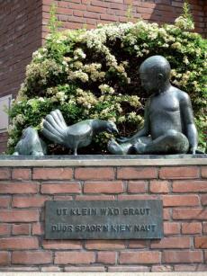 Skulptur vor mit Texttafel