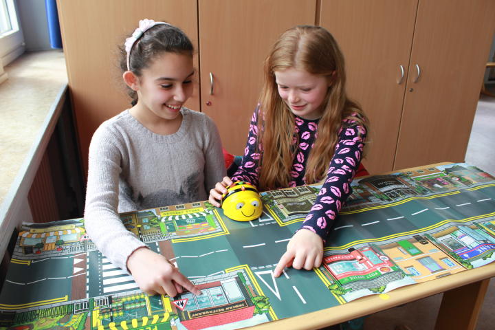 Schülerinnen und Schüler beim Programmieren mit dem Bee-Bot®