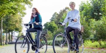 Zwei junge Frauen auf Fahrrädern