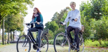 Zwei junge Frauen auf Fahrrädern