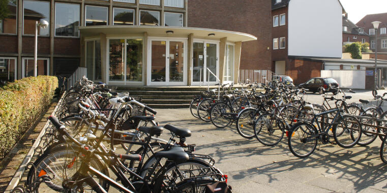 View of the entrance of the institute, in the foreground are a lot of bicycles