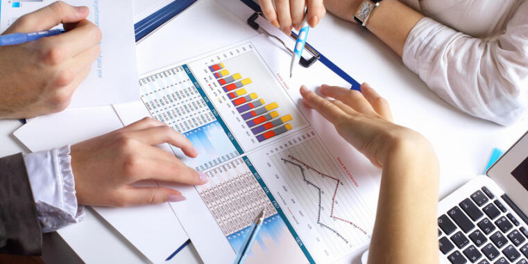 Hands showing diagrams on a table