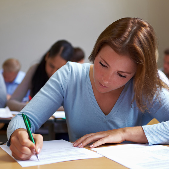 Eine Studentin notiert etwas auf einem Blatt Papier.