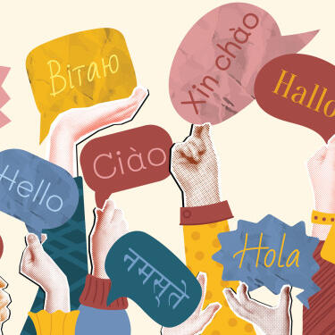 Hände halten bunte Sprechblasen hoch, in denen das Wort "Hallo" in verschiedenen Sprachen und Schriftzeichen steht.